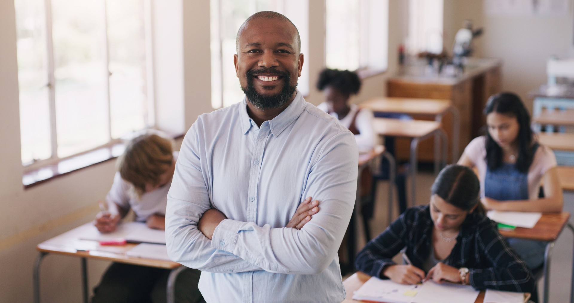 Portrait of mature man teaching a class of teenage students